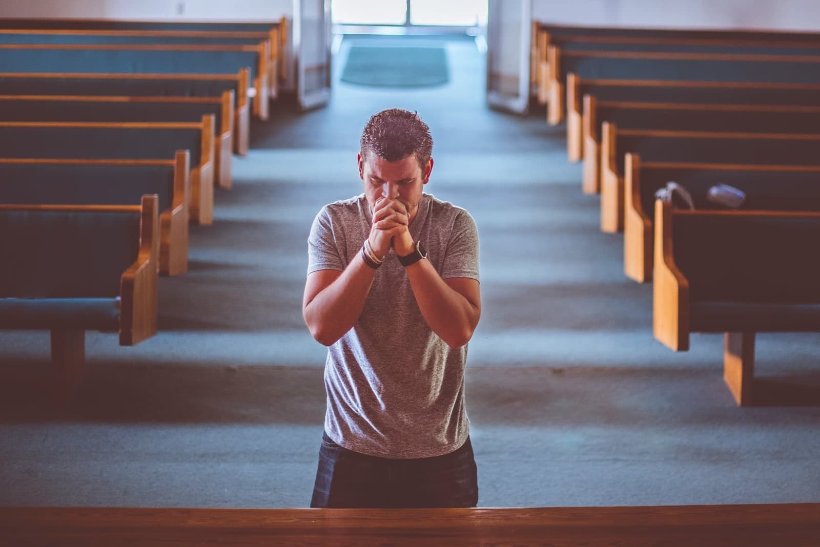 A man praying alone in a quiet sanctuary